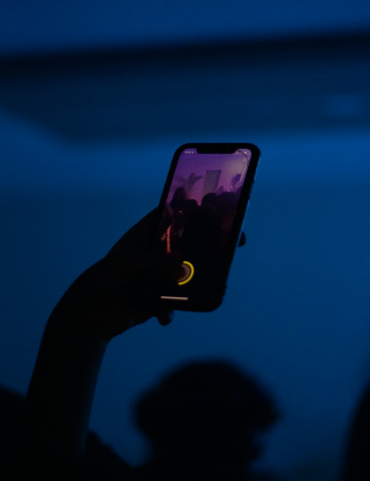Hand holding a phone against the night sky