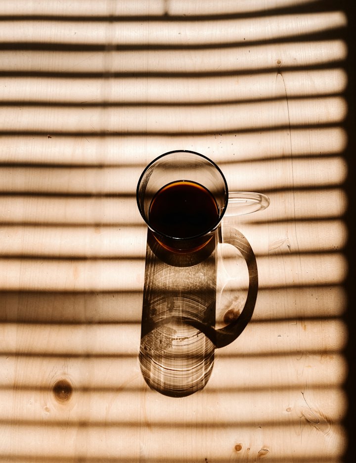 Drinking glass in striped morning light