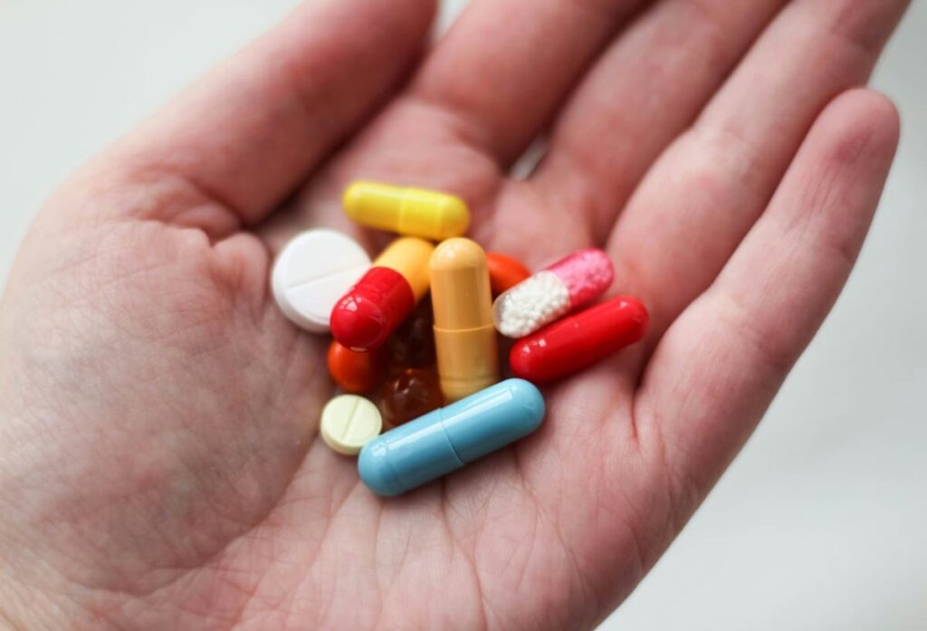 Loose tablets in an open hand, a warning against buying unverified HIV medicine instead of prescribed PEP in Thailand