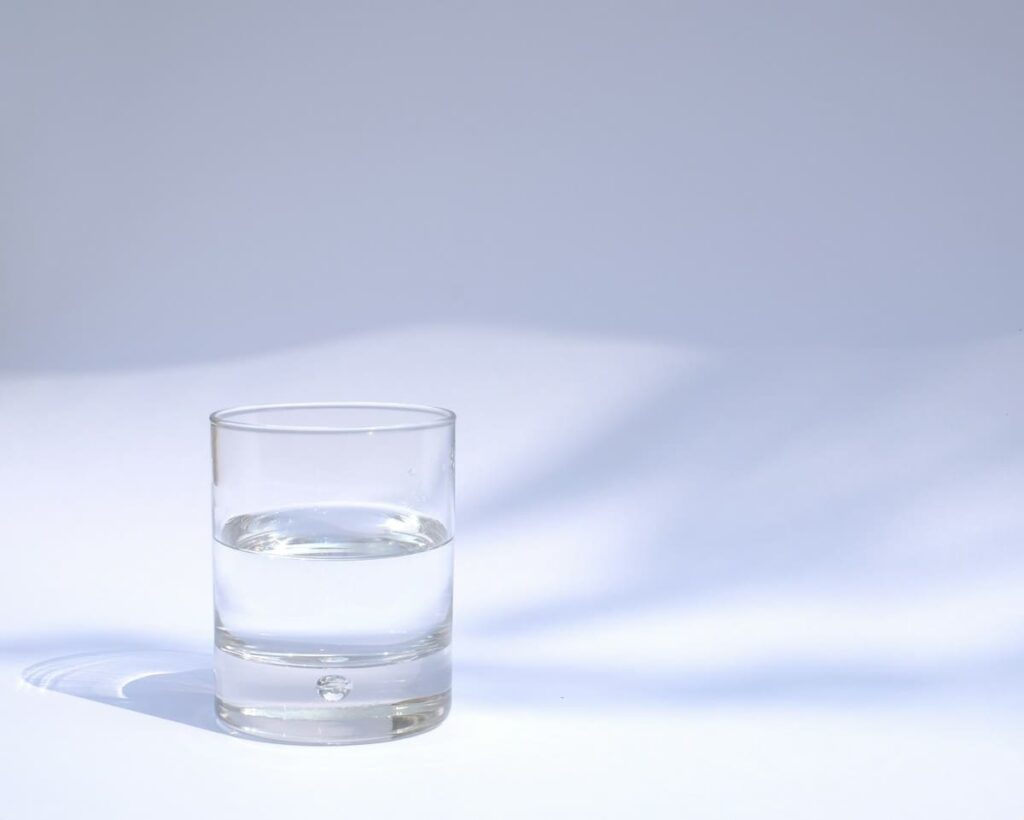 Glass of water on a table, a reminder not to urinate for an hour before a chlamydia urine test