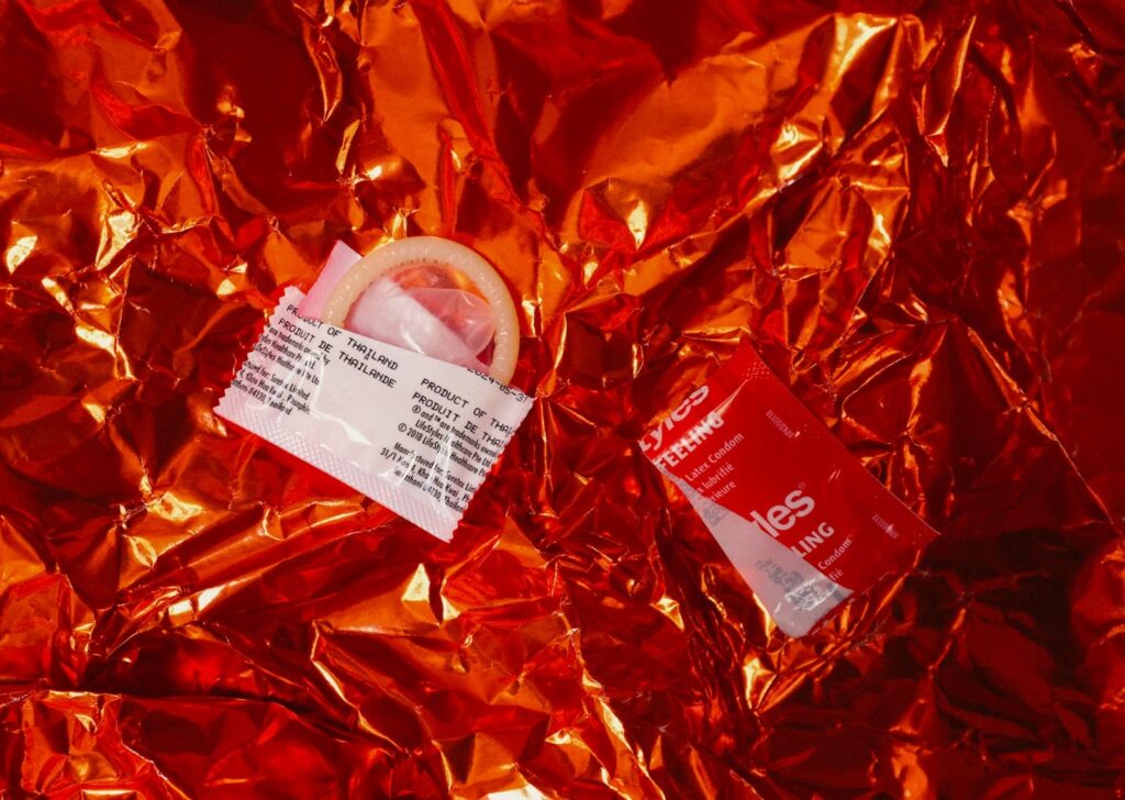 Condom packets on red foil, illustrating what to do when a condom broke on Koh Samui