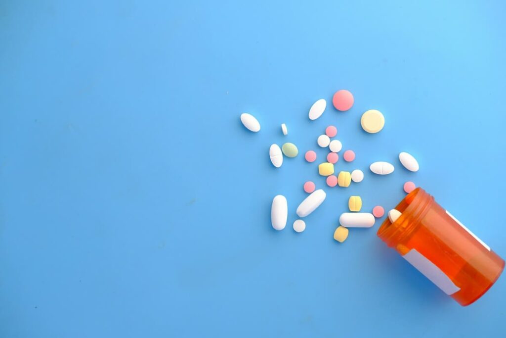 Pills spilling from a medicine bottle, a reminder to take every dose of PEP before follow-up HIV testing
