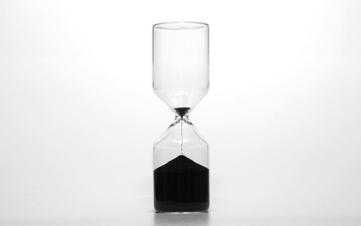 Hourglass with dark sand running through, illustrating the HIV window period before a test can detect infection
