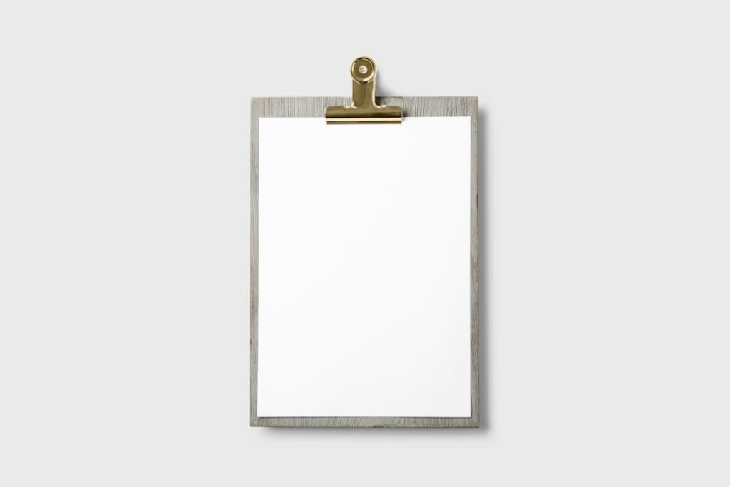 Blank clipboard on a white wall, where HIV test result wording is later explained