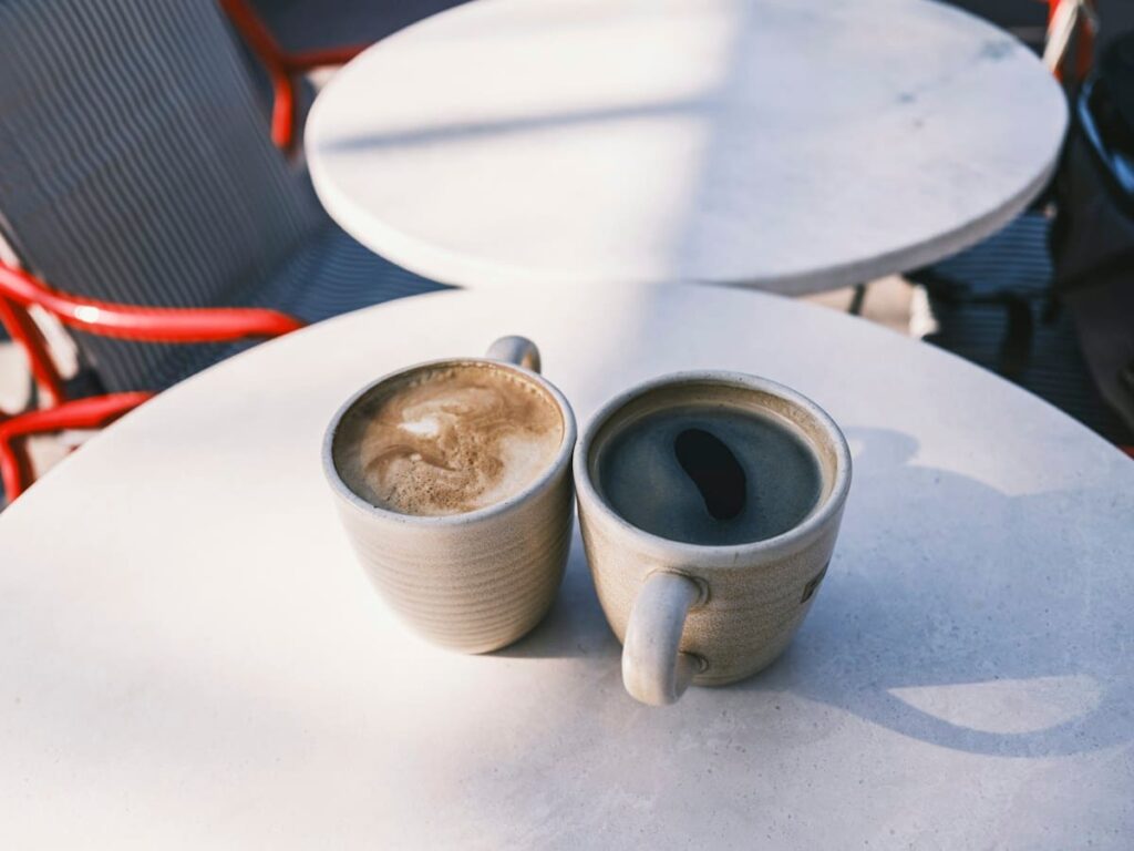 Two coffee cups on a cafe table, suggesting a relaxed and private conversation about LGBTQ+ sexual health