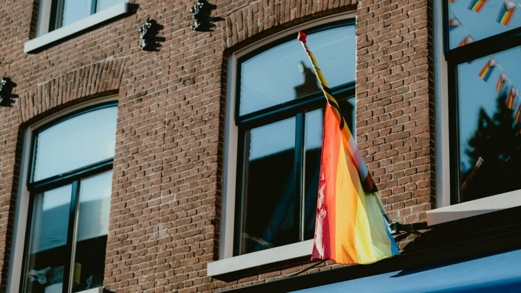 Small rainbow flag displayed in a window, a sign of LGBTQ-friendly sexual health care
