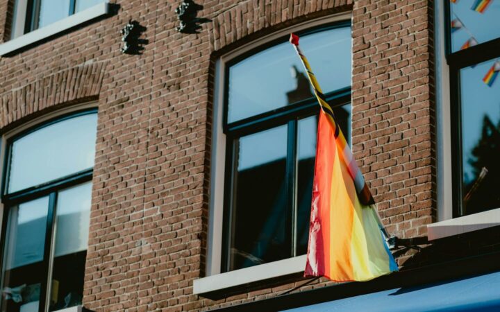 Small rainbow flag displayed in a window, a sign of LGBTQ-friendly sexual health care