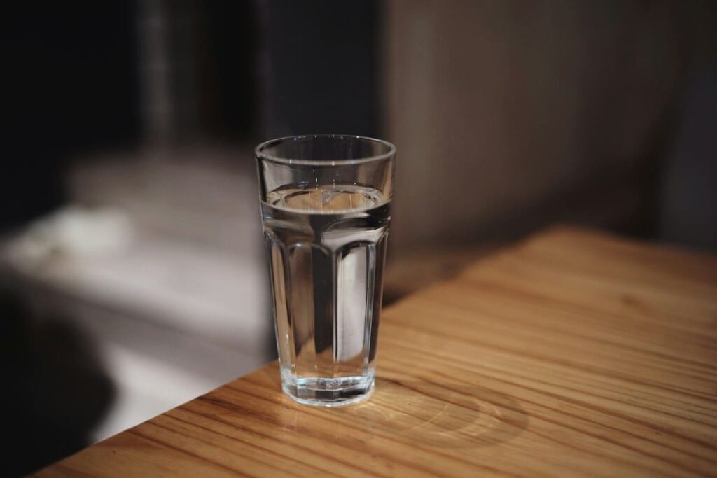 Glass of water on a table, representing common symptoms such as fever that cannot confirm or rule out HIV
