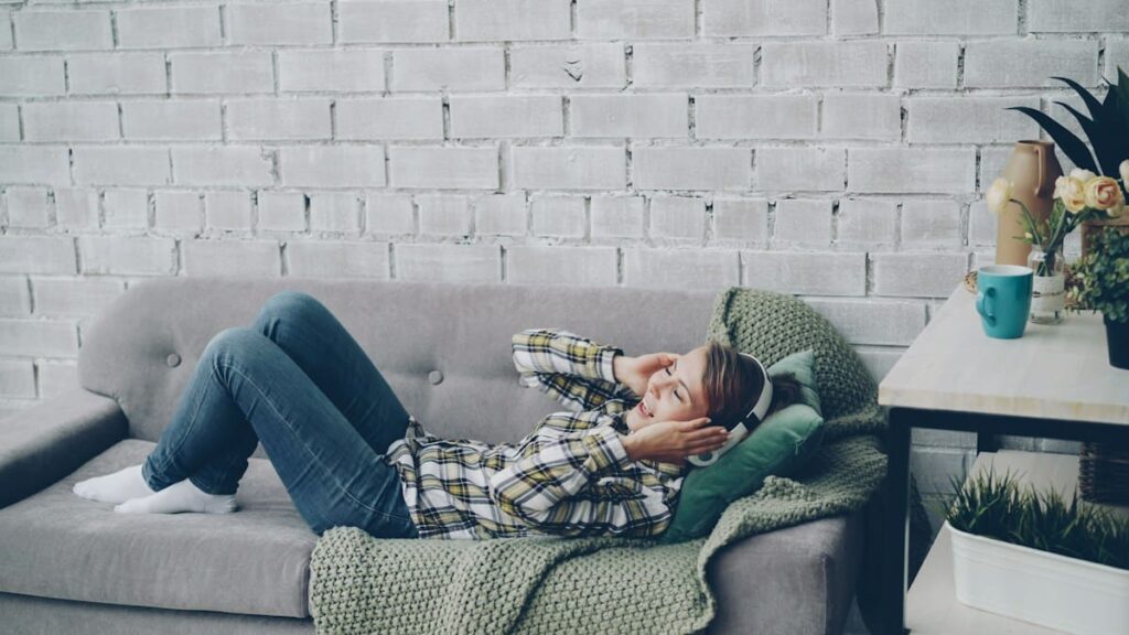 Blanket and cushion on a sofa, a reminder to rest when tiredness is a PEP side effect