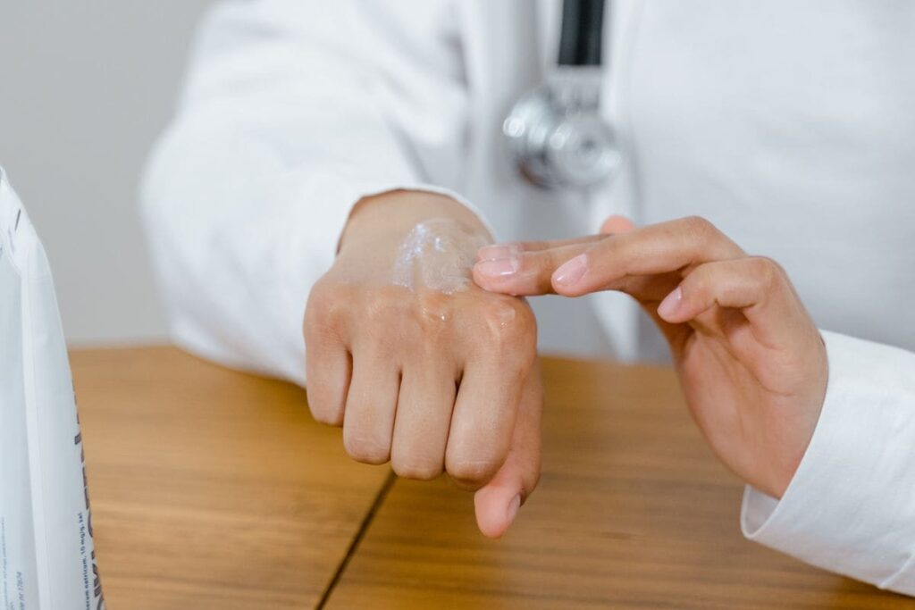 Doctor examining the skin on a hand, as when checking a rash during a PEP side effects review