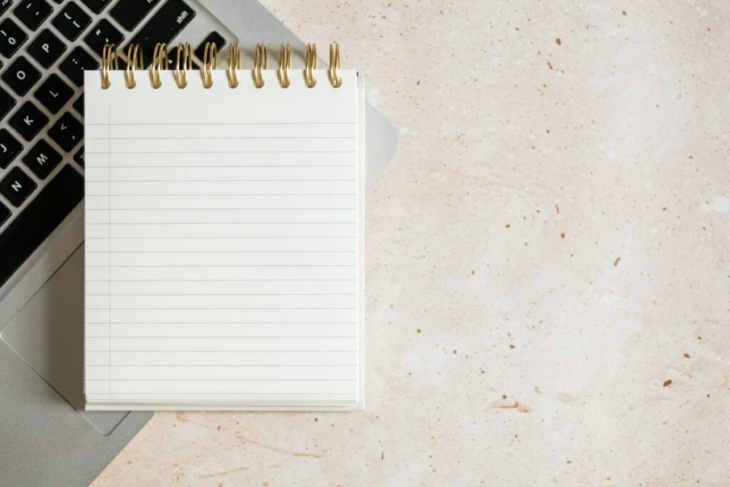 Open notebook and pen on a desk used as a symptom diary for tracking PEP side effects day by day