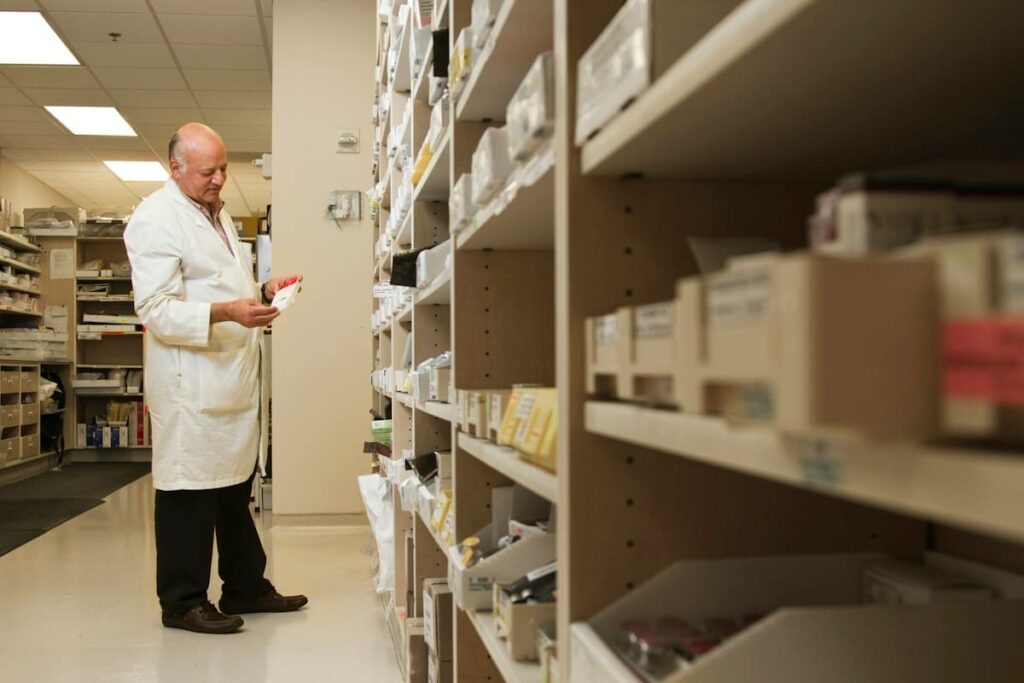 Pharmacist checking medicine shelves, a reminder that PrEP from a Thai pharmacy still needs tests first