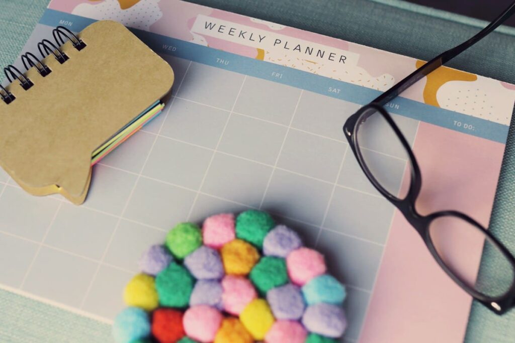 Weekly planner and glasses on a desk, showing a simple plan for STD tests at 2 weeks, 6 weeks and 3 months