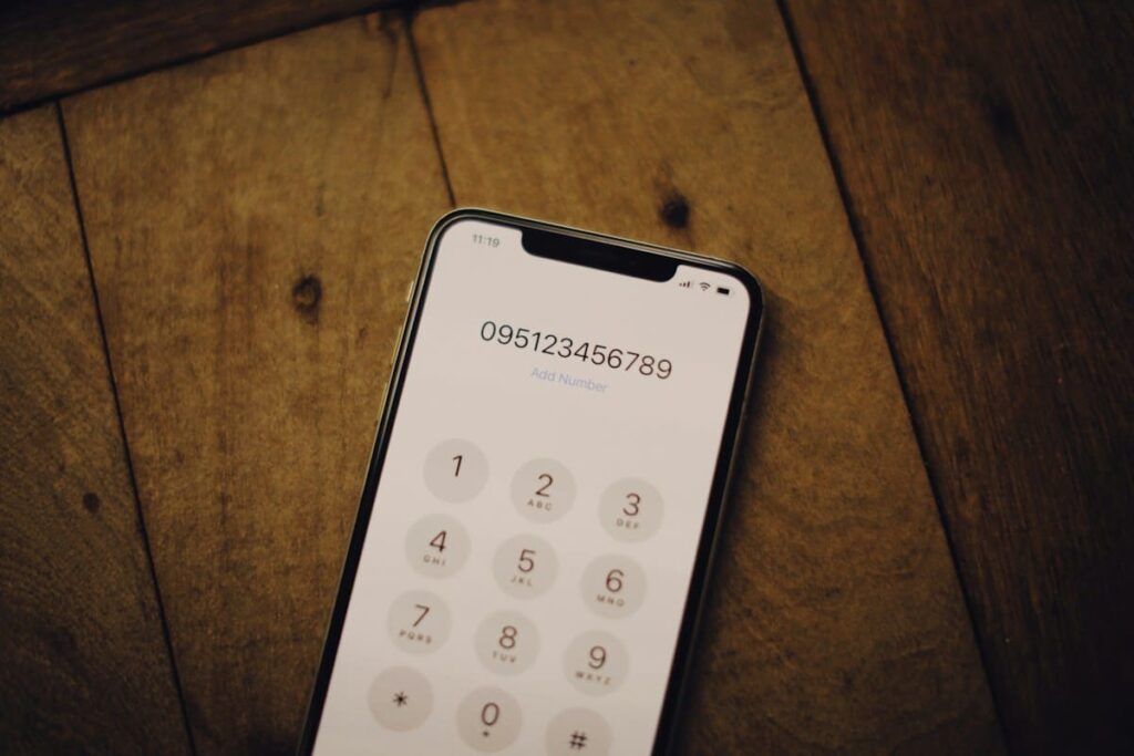 Phone keypad on a wooden table, a reminder to book a three-month syphilis retest